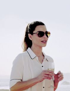 a woman holding a wine glass on the beach