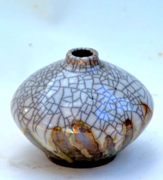 a white and brown vase sitting on top of a table