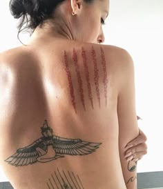 the back of a woman with tattoos on her chest