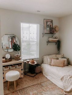 a bedroom with a bed, desk and mirror in it next to a window that has shutters