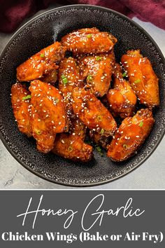 a black bowl filled with chicken wings covered in sesame seeds