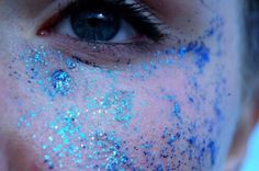 a woman with blue glitter on her face