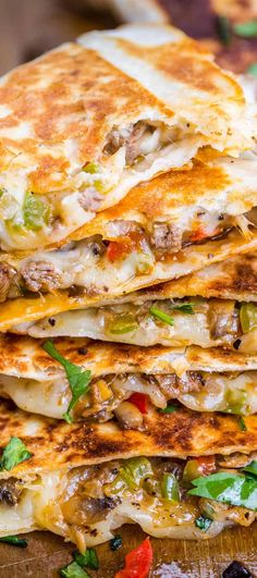 a stack of quesadilla on top of a wooden cutting board