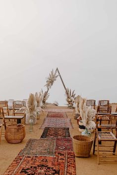 an outdoor ceremony setup with chairs and rugs