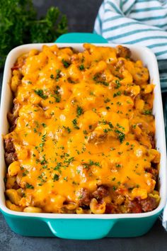 a casserole dish with cheese and meat in it on a blue serving dish