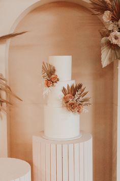 a three tiered white cake with flowers on top