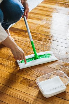 a woman is cleaning the floor with a mop