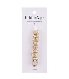 the gold and white beaded earring is packaged in a package