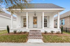 a white house with columns and steps leading to the front door