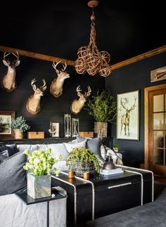 a living room filled with lots of furniture and deer head mounted on the wall above it