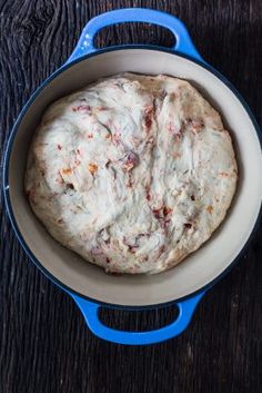 a blue and white pan filled with food on top of a wooden table