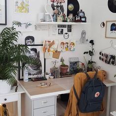 a room filled with lots of clutter and pictures on the wall above a desk