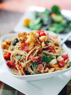 a white bowl filled with pasta and vegetables