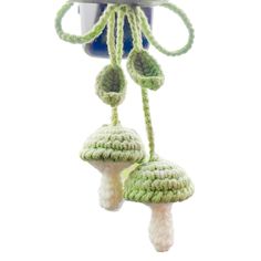 two crocheted mushrooms hanging from a hook