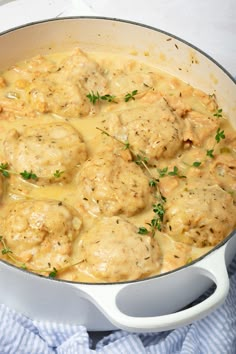 a pot filled with meatballs covered in gravy and garnished with parsley