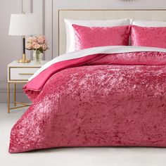 a pink bed with white sheets and pillows