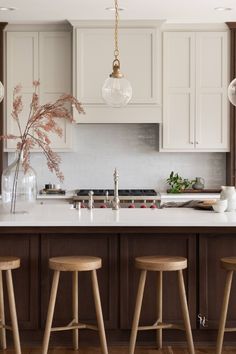 three stools sit in front of a kitchen island