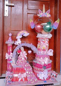 there is a pink castle with lots of decorations on the front door and behind it are balloons