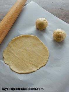 the dough is ready to be baked on the baking sheet with a rolling pin next to it