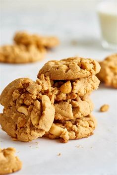 peanut butter cookies stacked on top of each other with a glass of milk in the background