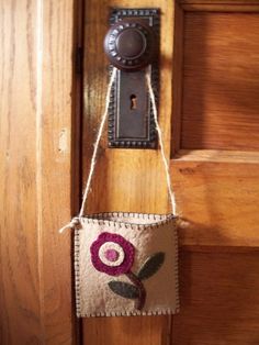 a door handle hanging from the side of a wooden door with a flower on it