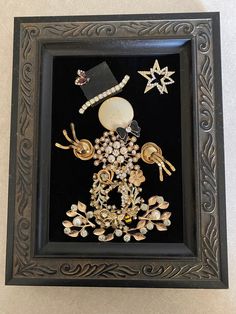 a black frame with some gold and white items in the center on top of it