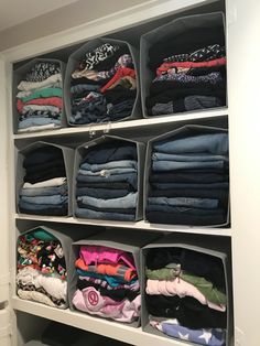 an organized closet filled with folded clothes and folded t - shirts in bins on shelves