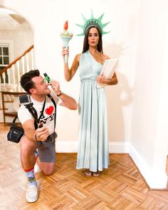 a man and woman dressed as the statue of liberty pose in front of an open doorway