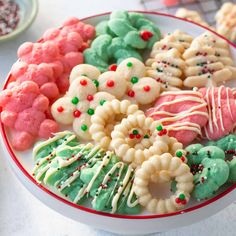 there are many cookies on the plate and one is decorated with icing, sprinkles, and candy