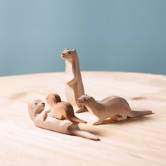 three wooden animals sitting on top of a wooden table