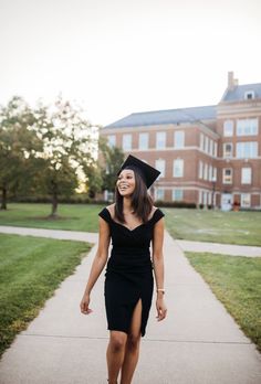 a woman wearing a graduation cap and gown walking down a sidewalk