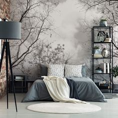 the bedroom is decorated in black and white with trees on the wall, along with grey bedding