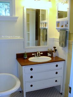 a white sink sitting under a bathroom mirror next to a bath tub and toilet bowl