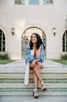 a woman is sitting on some steps smiling