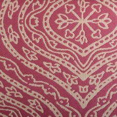 a red and white pillow with an intricate design on it's back side,