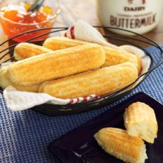 corn dogs on a plate with butter in the background