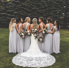 a group of bridesmaids standing in front of some trees