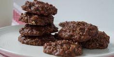 chocolate cookies stacked on top of each other on a plate with a cup in the background