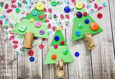 three christmas trees made out of paper with buttons on them and corks in the middle