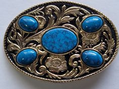 "WESTERN BELT BUCKLE-imitation turquoise stone on gold/black background western buckle-FOR UP TO 2-1/8\"\" BELT. MADE IN USA" Western Belts With Antique Buckle And Adjustable Fit, Gold Black Background, Western Style Blue Concho Belt Buckles, Blue Concho Western Belt Buckles, Round Turquoise Buckle, Gold And Black Background, Turquoise Bohemian Belt Buckle With Antique Detail, Silver Antique Buckle Belt Buckles For Western-themed Events, Background Western