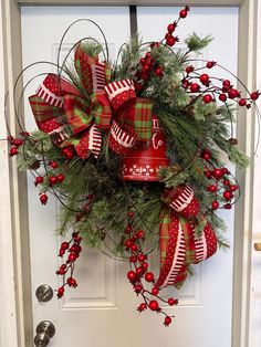 a red and green christmas wreath on the front door