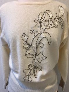 "White Lambswool Angora Pullover Sweater with Beaded Embroidered Leaf Design, by Renee Tener for Jeanne Pierre Size Medium This sweater is almost perfect except for 1 small mend job (pic no. 8) Features are a 3\" sock bottom along with end of sleeves, shoulder pads that can be removed and a beautiful beaded embroidered design on the front. The tube beads look like a dark silver and they edge the design that is filled with shimmery white embroidery stitches and also silver stud like beads. Really Elegant Embroidered Winter Sweater, Elegant White Embroidered Sweater, Elegant Embroidered Winter Tops, Elegant Floral Embroidered Tops For Winter, Cream Embroidered Fitted Sweater, Fitted Cream Embroidered Sweater, Job Pic, Job Pictures, Embroidered Leaf