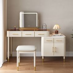 a white dressing table with a mirror and stool next to it on top of a hard wood floor