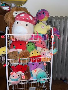 several stuffed animals are sitting on a wire rack