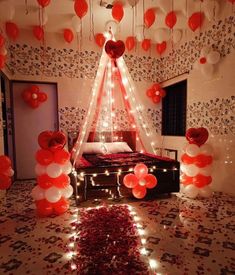 a bedroom decorated for valentine's day with red and white balloons hanging from the ceiling