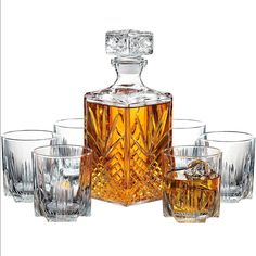 an old fashioned decanter set with four glasses and a whiskey bottle on the side