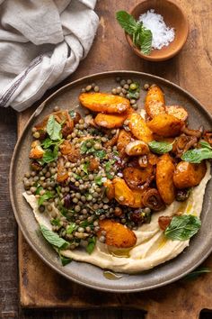 a plate filled with food on top of a wooden table next to two small bowls