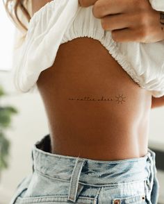 the back of a woman's stomach with an arrow tattoo on her left side