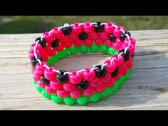 two different colored bracelets sitting on top of a wooden table