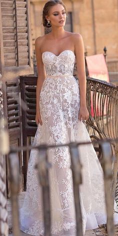 a woman in a wedding dress standing on a balcony